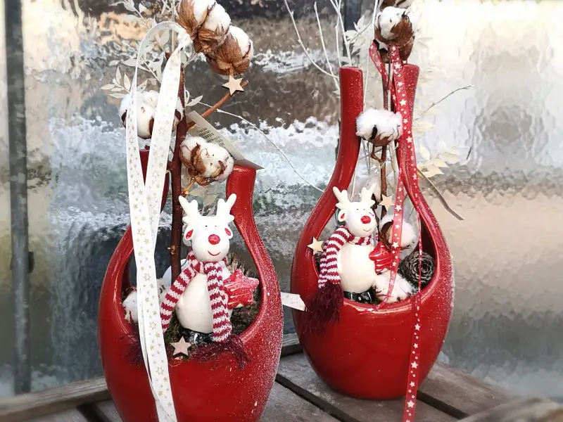 Compositions de Noël en vases rouges, rennes et coton